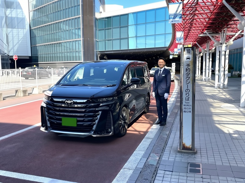 新千歳空港の予約タクシー乗り場でお客様をお迎えする専属ドライバーと高級ハイヤー「アルファード」